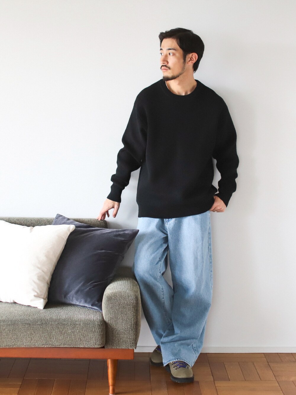 ブラック系のニット/セーター、ブルー系のデニムパンツを着用したメンズの秋コーディネートの2枚目の写真