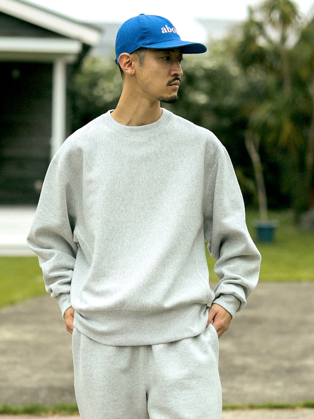 グレー系のスウェット、グレー系のスウェットパンツ、ブルー系のキャップを着用したメンズの秋コーディネートの3枚目の写真