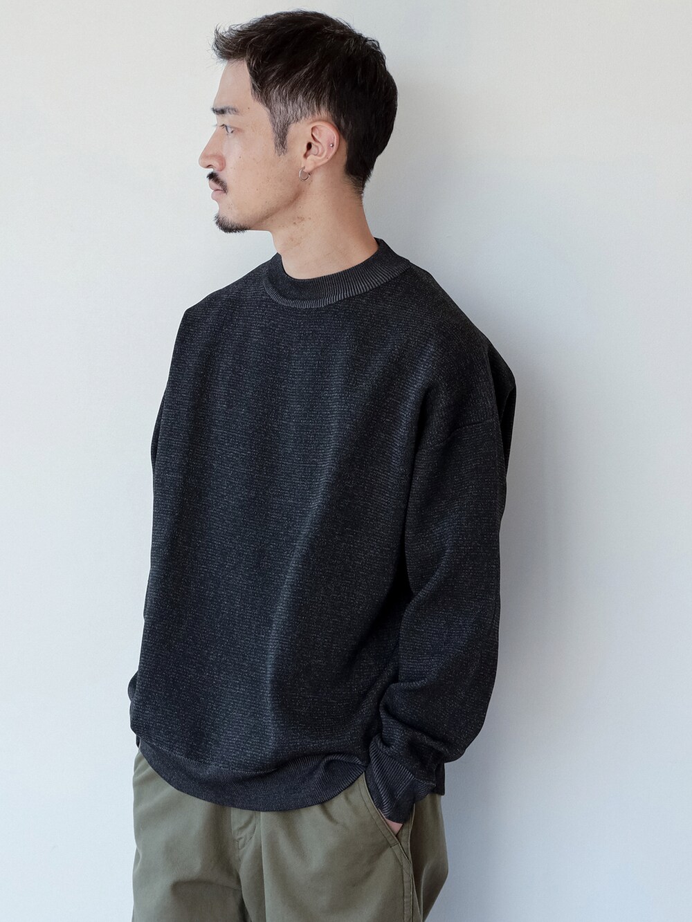 グリーン系のチノパンツ、ブラック系のスウェットを着用したメンズの秋コーディネートの2枚目の写真