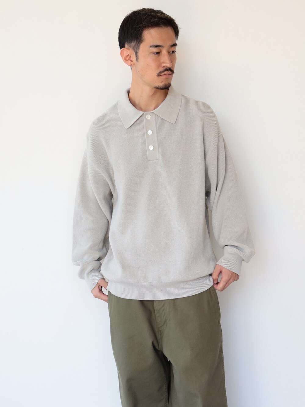 グレー系のポロシャツを着用したメンズの秋コーディネートの2枚目の写真