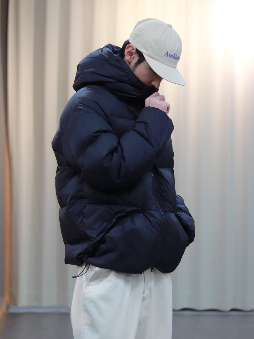 ブラック系のダウンジャケット/コート、ホワイト系のその他パンツ、ブラウン系のスニーカーを着用したメンズの秋コーディネートの4枚目の写真