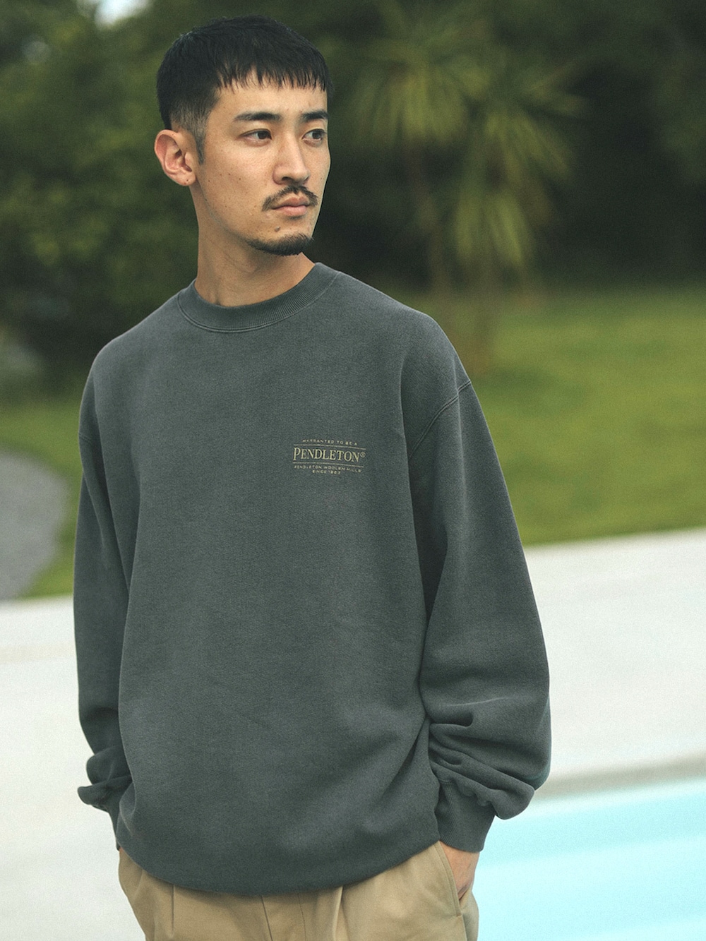 グレー系のスウェット、ベージュ系のチノパンツを着用したメンズの秋コーディネートの3枚目の写真