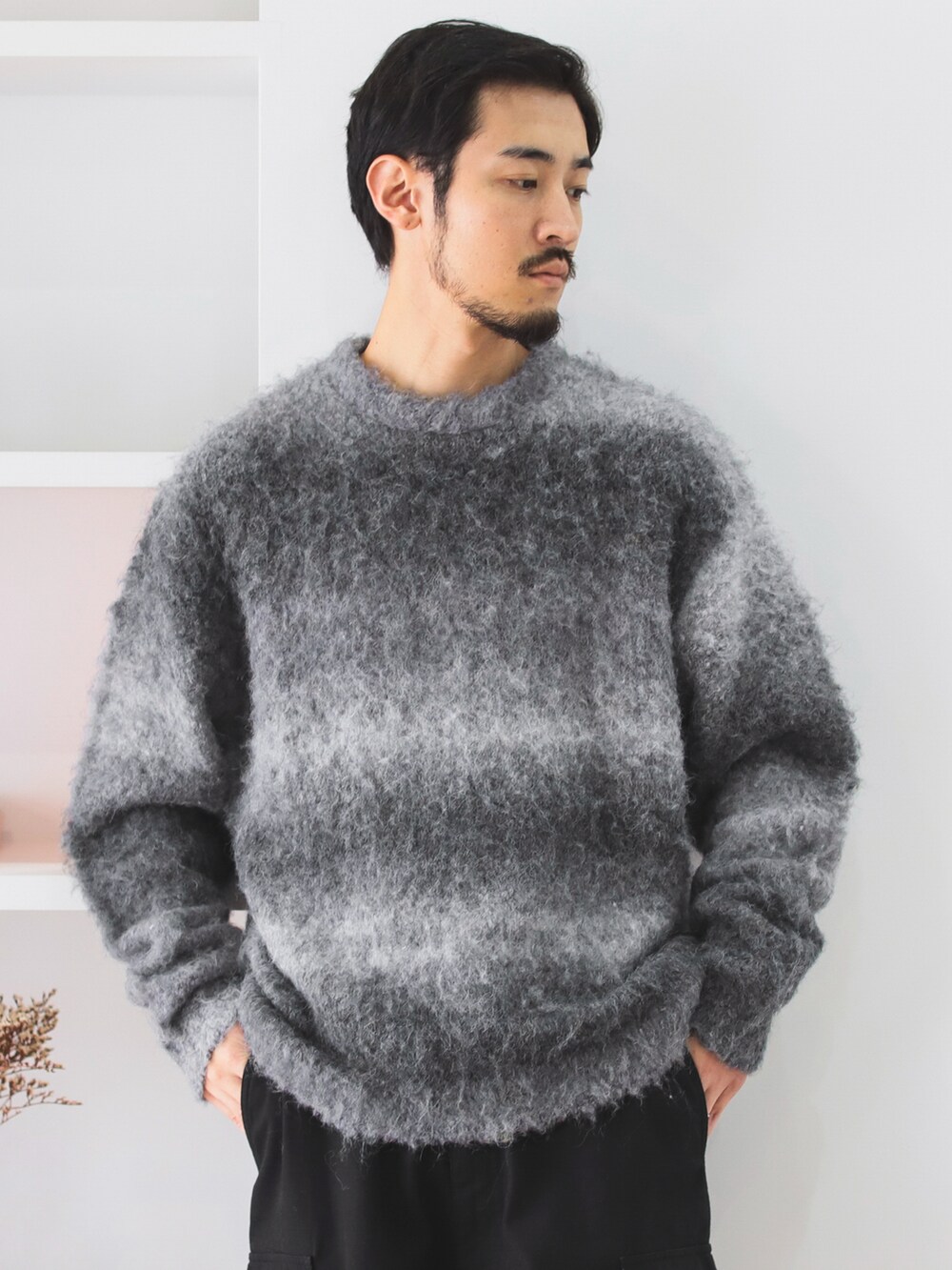 グレー系のニット/セーター、ブラック系のカーゴパンツ、ベージュ系のブーツを着用したメンズの秋コーディネートの3枚目の写真