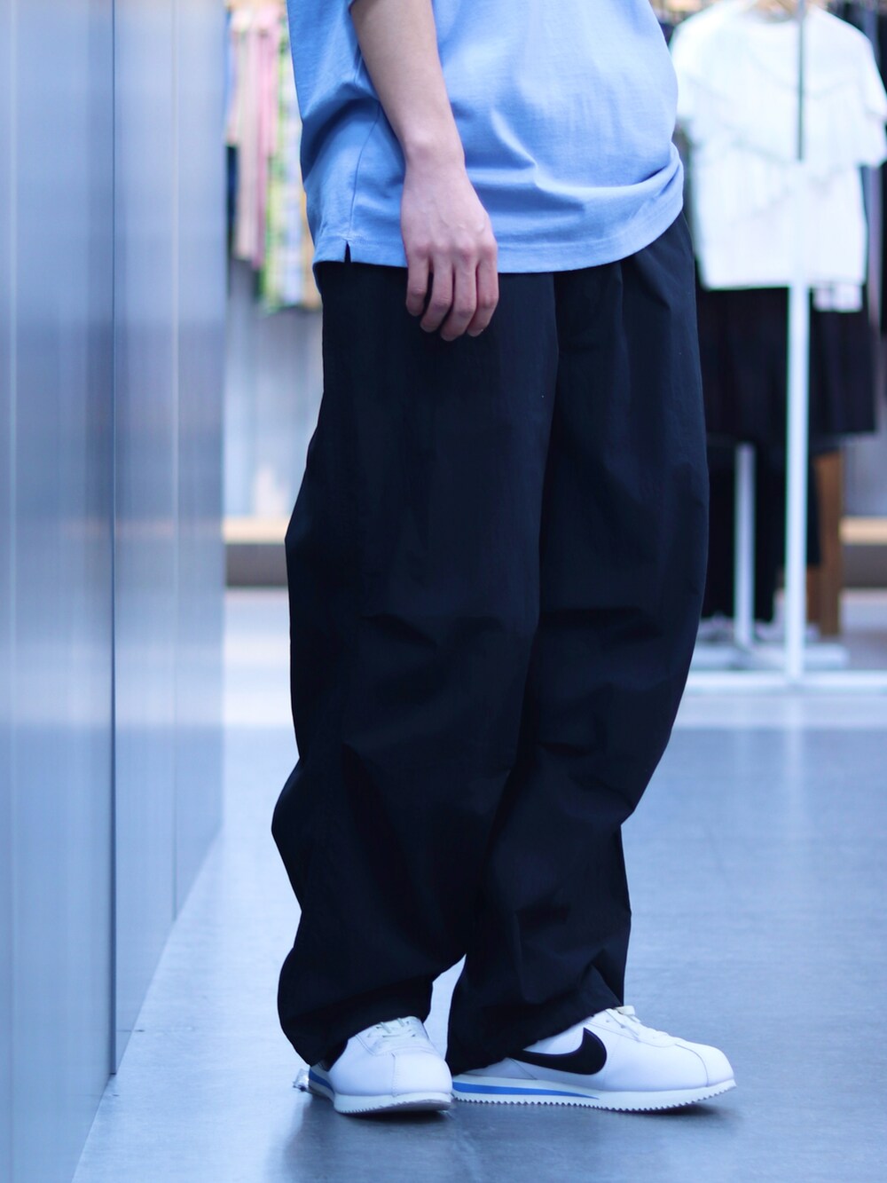 ブルー系のTシャツ/カットソー、ブラック系のその他パンツ、ホワイト系のスニーカーを着用したメンズの春コーディネートの4枚目の写真