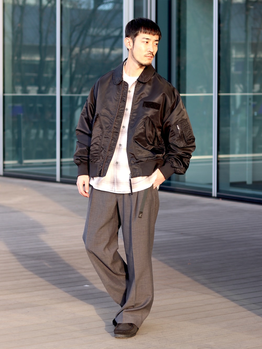 ブラック系のミリタリージャケット、グレー系のシャツ/ブラウス、グレー系のその他パンツを着用したメンズの冬コーディネートの2枚目の写真