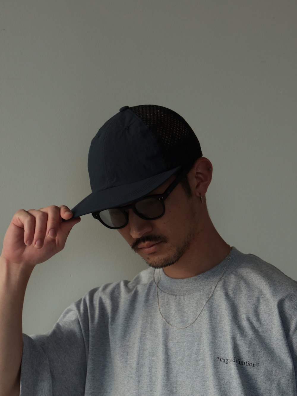 ホワイト系のスニーカー、ブルー系のキャップを着用したメンズの夏コーディネートの3枚目の写真