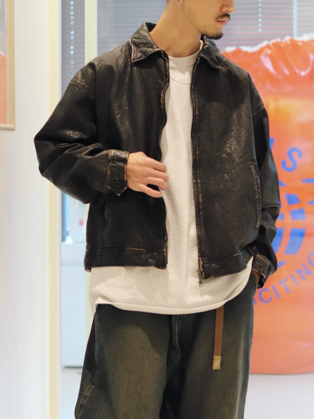 ブルー系のデニムパンツ、ブラック系のブルゾンを着用したメンズの夏コーディネートの3枚目の写真