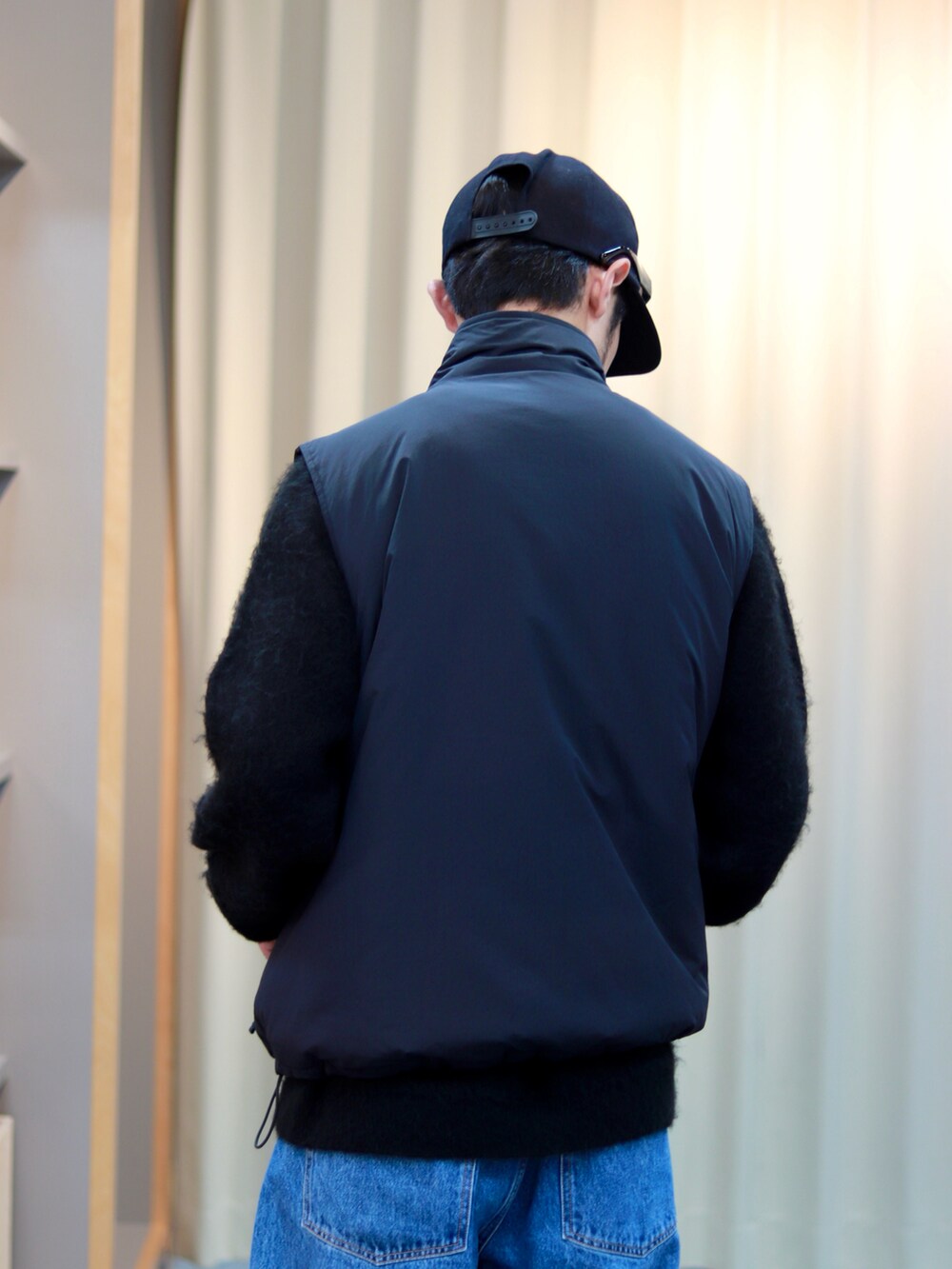 ブラック系のブルゾン、ブルー系のデニムパンツ、ブラック系のブーツを着用したメンズの秋コーディネートの4枚目の写真