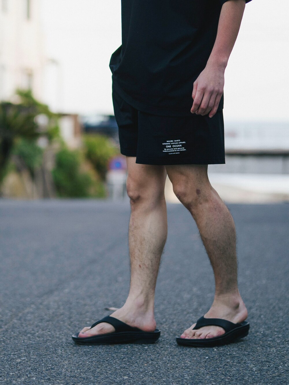 ブラック系のTシャツ/カットソー、ブラック系のその他パンツ、ブラック系のサンダルを着用したメンズの夏コーディネートの3枚目の写真