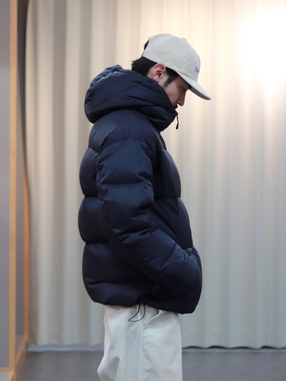 ブラック系のダウンジャケット/コート、ホワイト系のその他パンツ、ブラウン系のスニーカーを着用したメンズの秋コーディネートの5枚目の写真