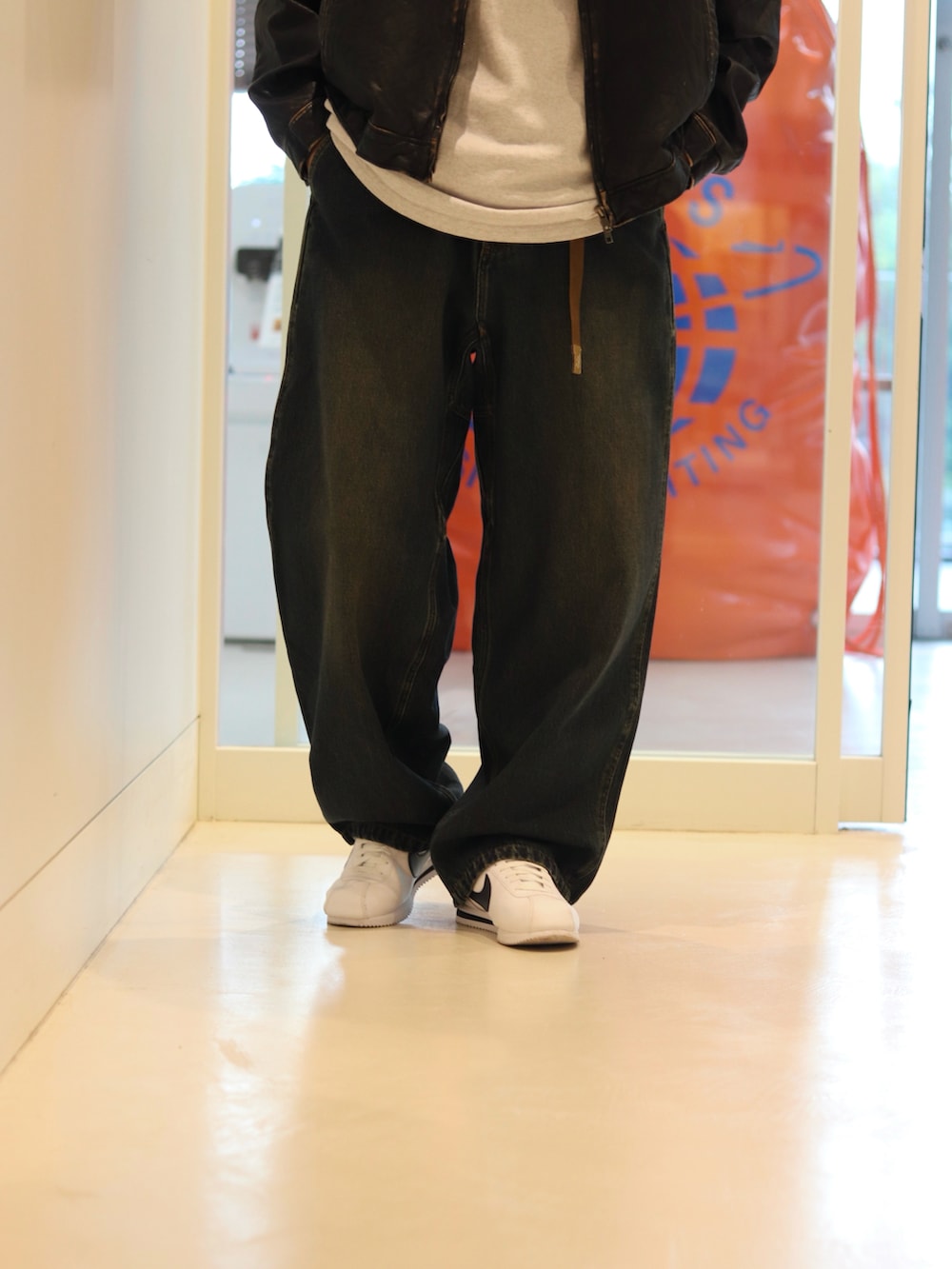 ブルー系のデニムパンツ、ブラック系のブルゾンを着用したメンズの夏コーディネートの4枚目の写真