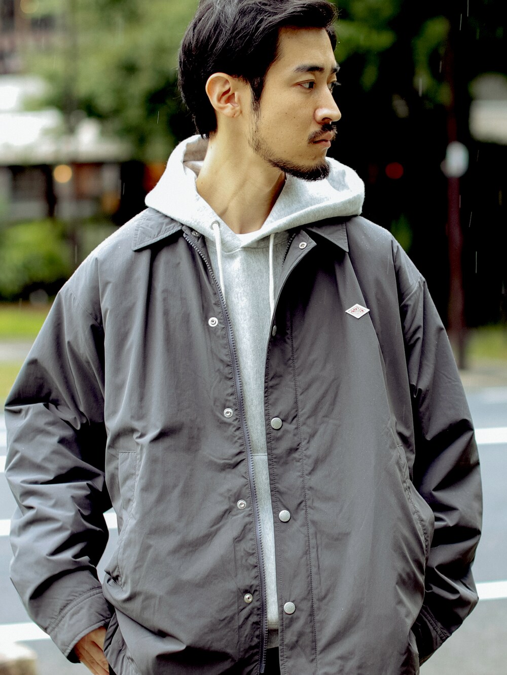 グレー系のパーカー、ブラック系のその他パンツを着用したメンズの秋コーディネートの2枚目の写真