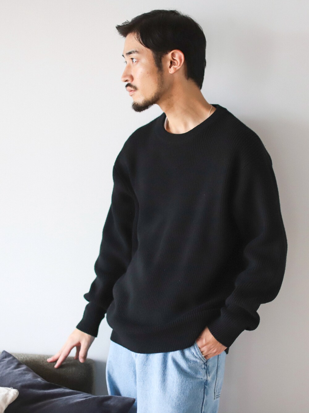 ブラック系のニット/セーター、ブルー系のデニムパンツを着用したメンズの秋コーディネートの3枚目の写真