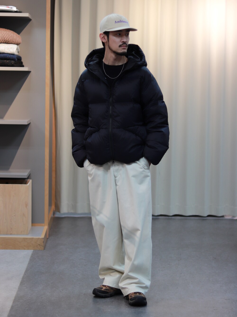 ブラック系のダウンジャケット/コート、ホワイト系のその他パンツ、ブラウン系のスニーカーを着用したメンズの秋コーディネートの3枚目の写真