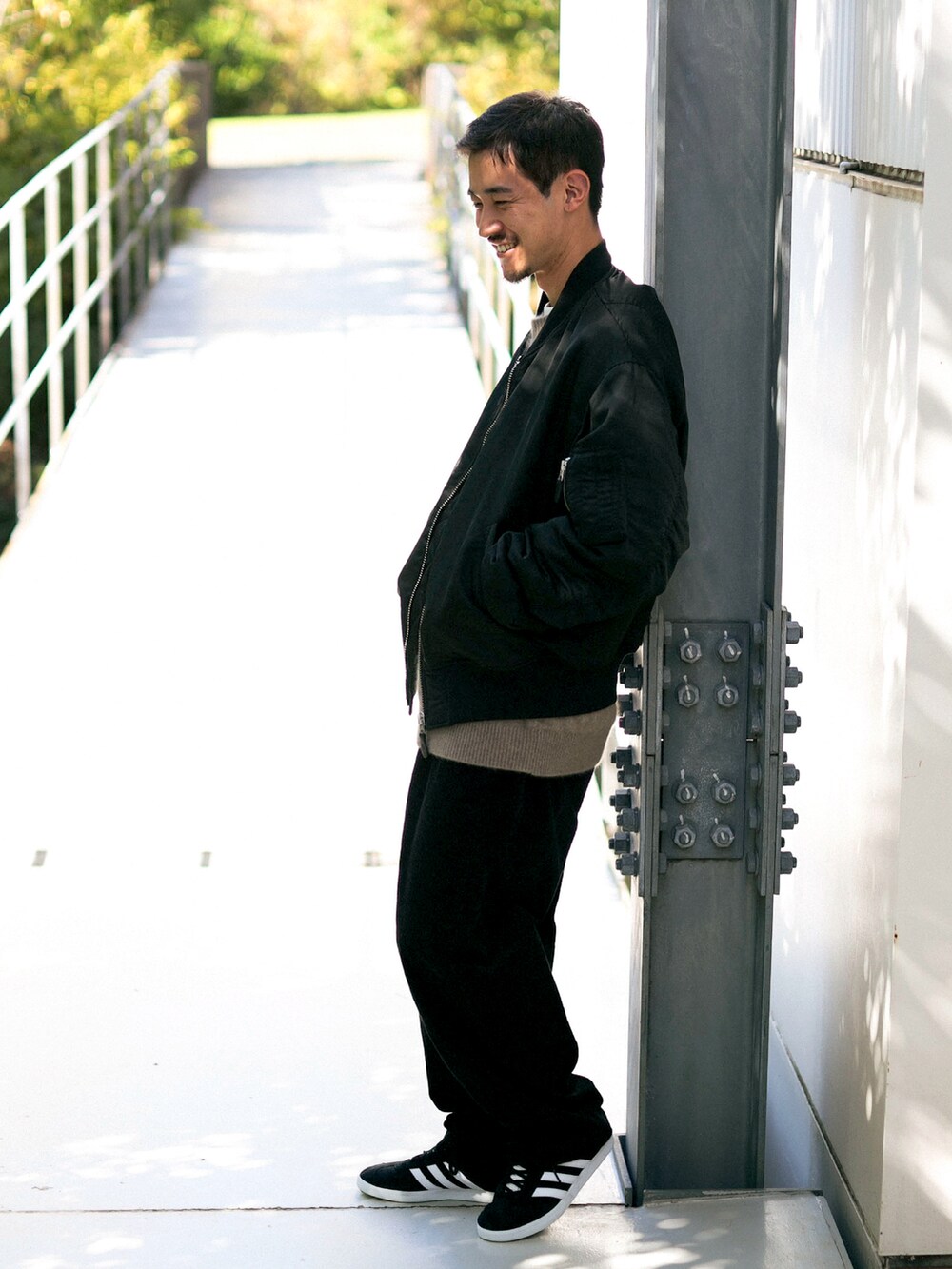 ブラック系のMA-1、ブラック系のスニーカー、ベージュ系のニット/セーターを着用したメンズの春コーディネートの2枚目の写真