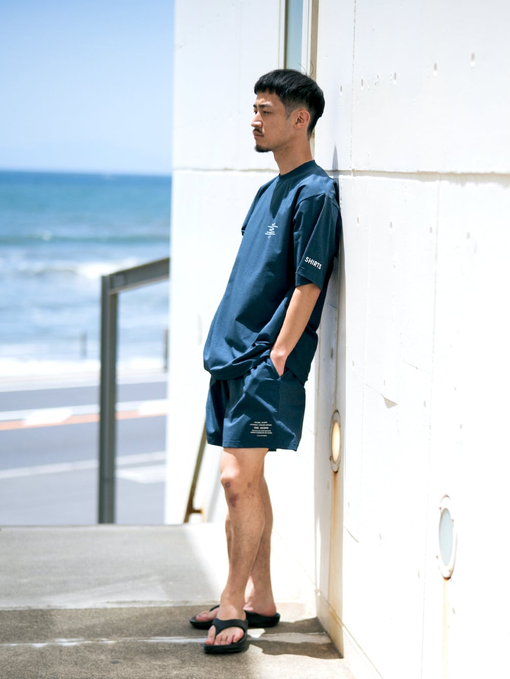 ブルー系のその他パンツ、ブルー系のTシャツ/カットソー、ブラック系のサンダルを着用したメンズの夏コーディネートの2枚目の写真