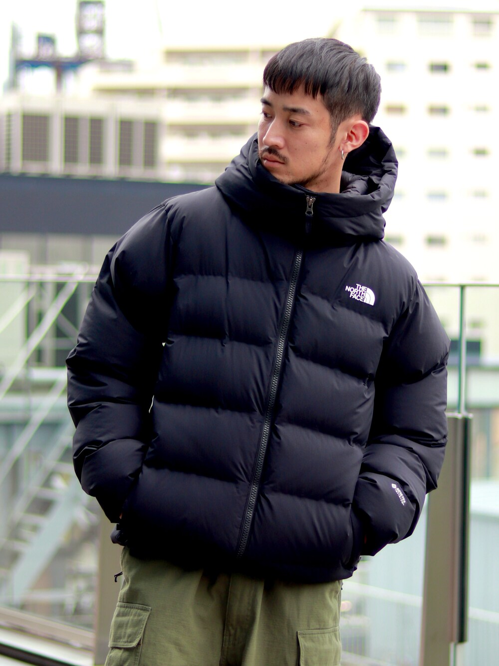 ブラック系のダウンジャケット/コート、グリーン系のカーゴパンツを着用したメンズの秋コーディネートの4枚目の写真