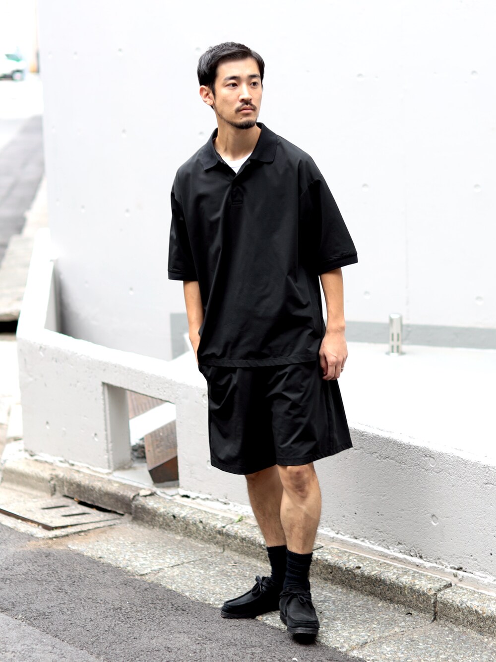 ブラック系のポロシャツ、ブラック系のその他パンツを着用したメンズの秋コーディネートの2枚目の写真