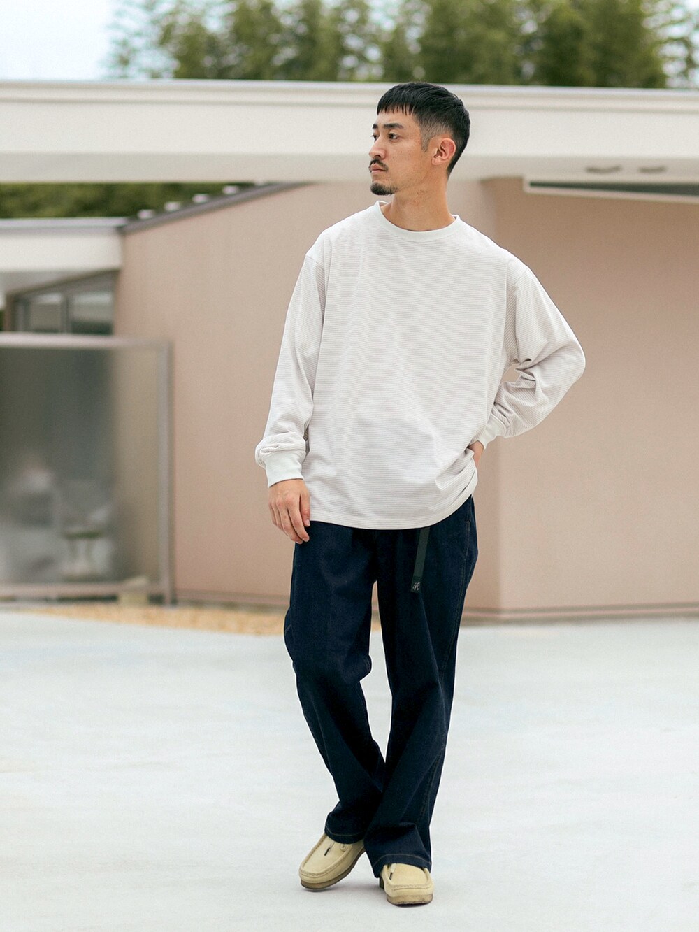 ベージュ系のTシャツ/カットソー、ブルー系のデニムパンツを着用したメンズの秋コーディネートの2枚目の写真