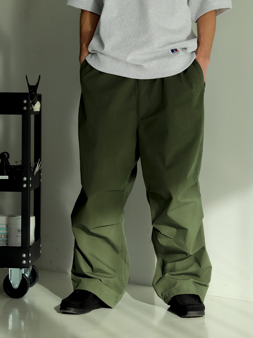 グレー系のTシャツ/カットソー、グリーン系のその他パンツを着用したメンズの冬コーディネートの4枚目の写真