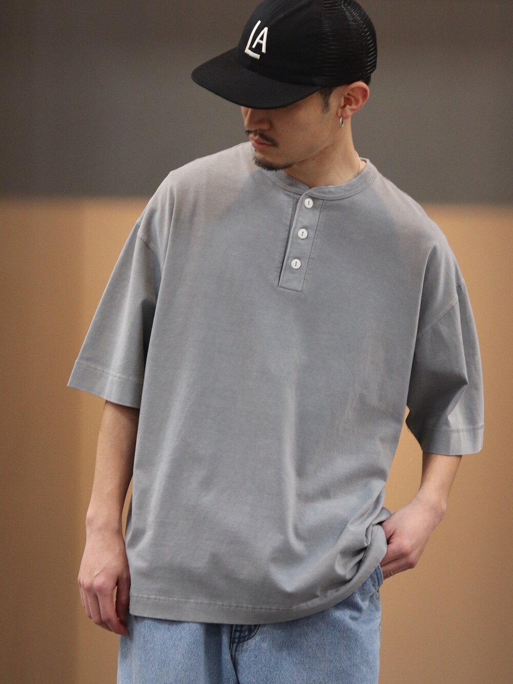 ブラック系のTシャツ/カットソー、ブルー系のデニムパンツ、ブラック系のキャップを着用したメンズの春コーディネートの3枚目の写真