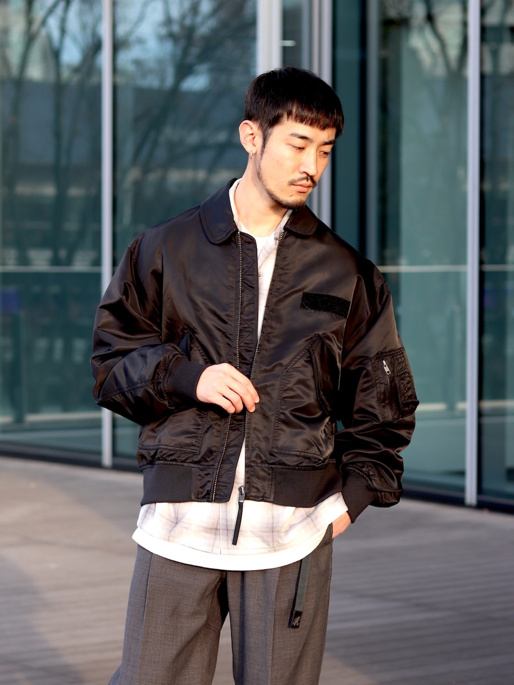 ブラック系のミリタリージャケット、グレー系のシャツ/ブラウス、グレー系のその他パンツを着用したメンズの冬コーディネートの3枚目の写真