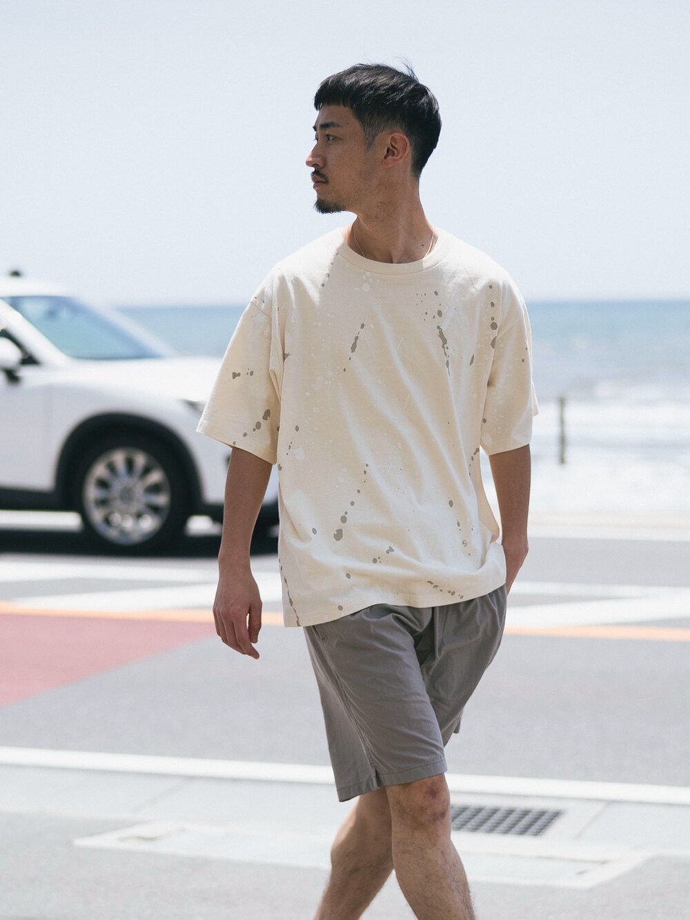 ホワイト系のTシャツ/カットソー、グレー系のその他パンツ、ブラック系のサンダルを着用したメンズの夏コーディネートの3枚目の写真