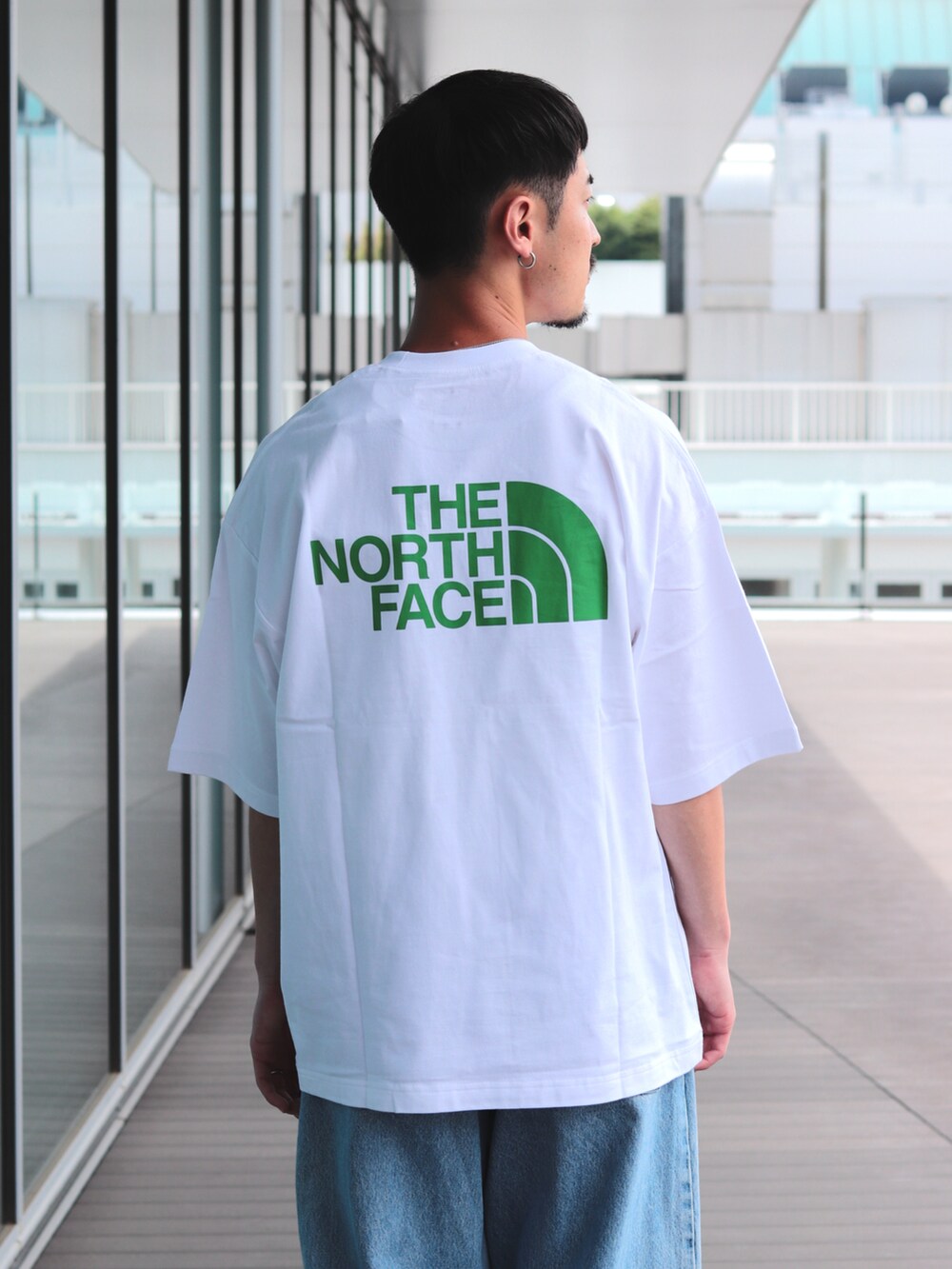 ブルー系のデニムパンツ、ホワイト系のTシャツ/カットソーを着用したメンズの春コーディネートの5枚目の写真
