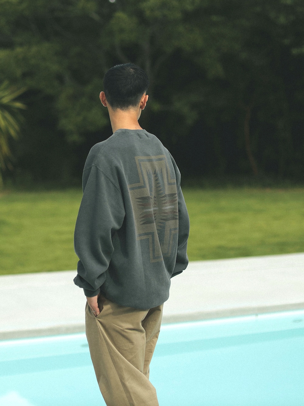 グレー系のスウェット、ベージュ系のチノパンツを着用したメンズの秋コーディネートの2枚目の写真