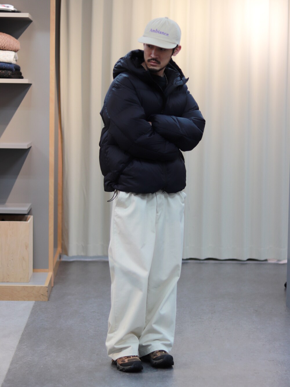 ブラック系のダウンジャケット/コート、ホワイト系のその他パンツ、ブラウン系のスニーカーを着用したメンズの秋コーディネートの2枚目の写真