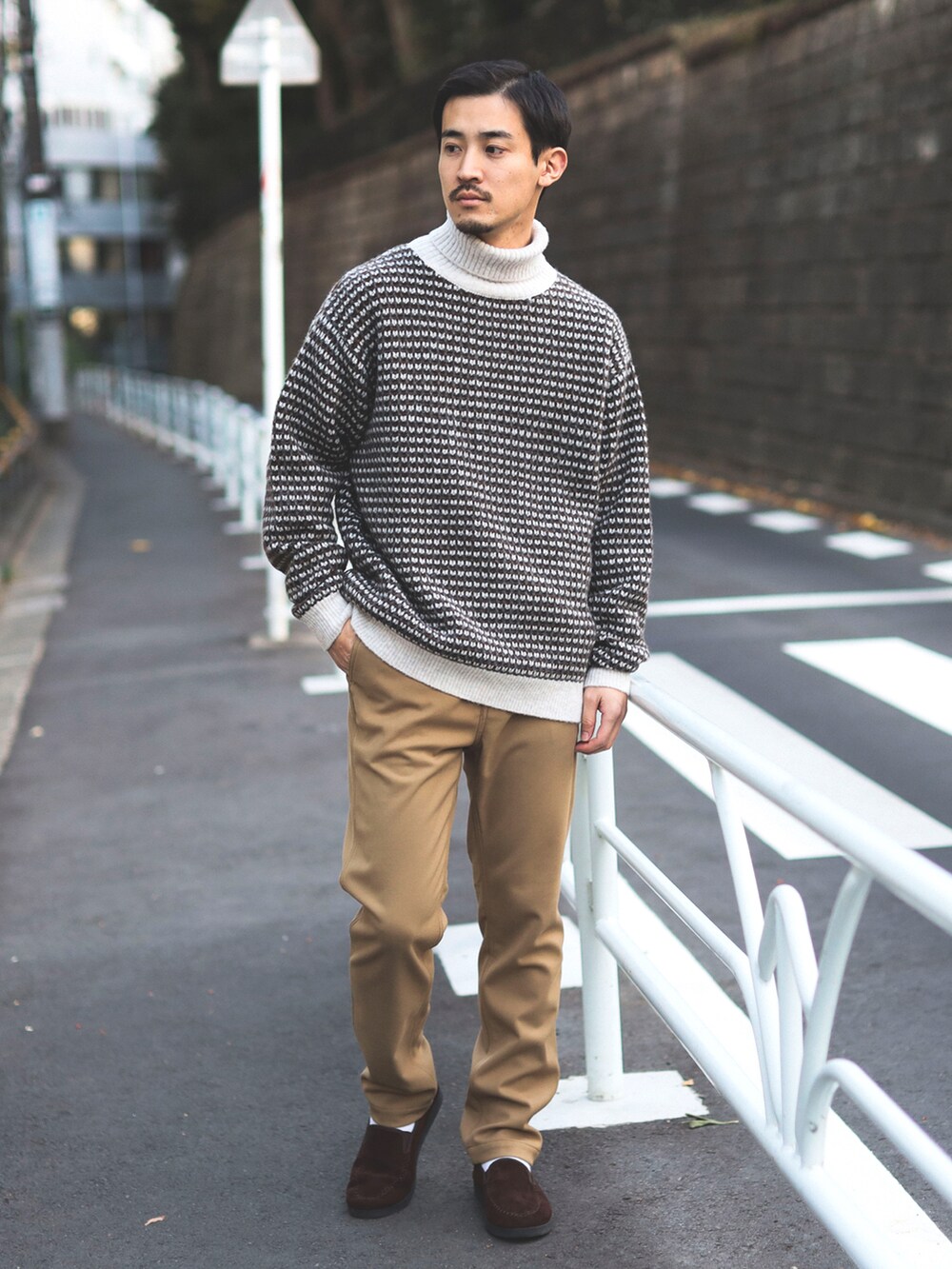 ホワイト系のニット/セーター、ベージュ系のチノパンツを着用したメンズの秋コーディネートの2枚目の写真