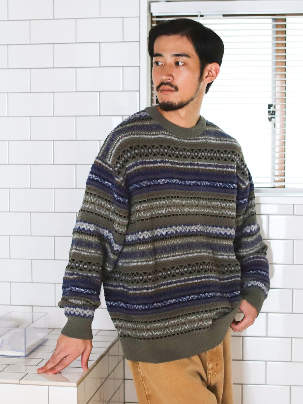 グリーン系のニット/セーター、ベージュ系のその他パンツ、ベージュ系のブーツを着用したメンズの秋コーディネートの2枚目の写真