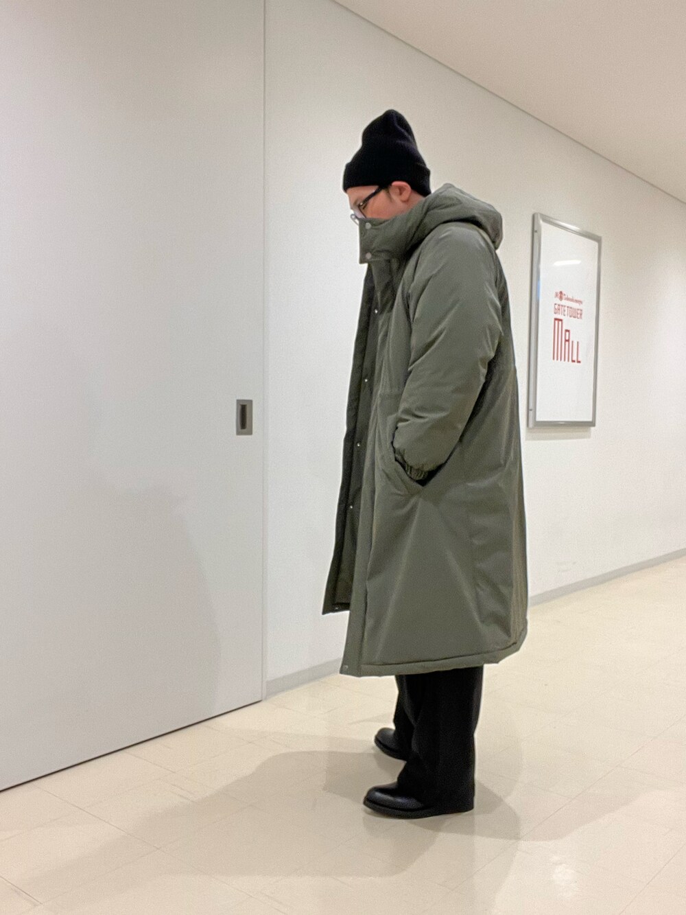 ホワイト系のニット/セーター、グリーン系のその他アウター、ブラック系のその他パンツを着用したメンズの秋コーディネートの4枚目の写真