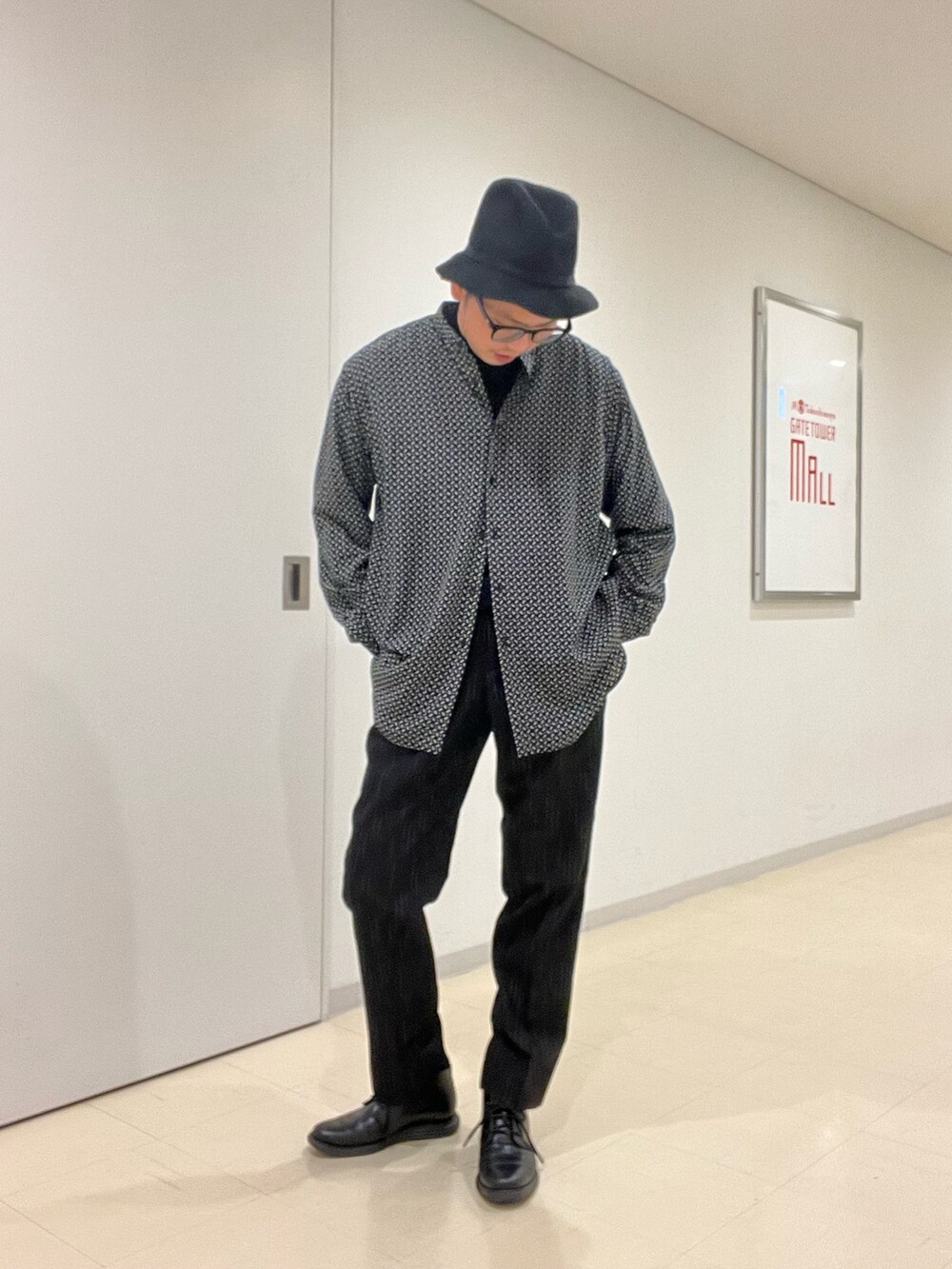 ブラック系のニット/セーター、ベージュ系のシャツ/ブラウス、ベージュ系のダウンジャケット/コートを着用したメンズの秋コーディネートの4枚目の写真