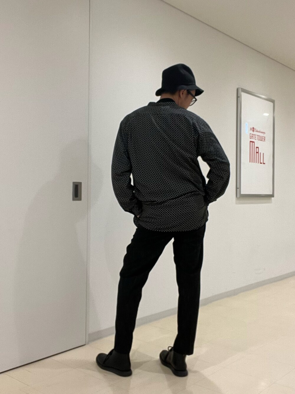 ブラック系のニット/セーター、ベージュ系のシャツ/ブラウス、ベージュ系のダウンジャケット/コートを着用したメンズの秋コーディネートの5枚目の写真