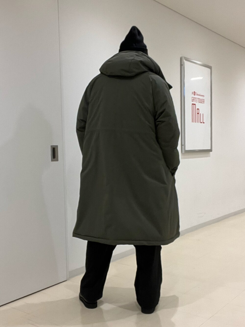 ホワイト系のニット/セーター、グリーン系のその他アウター、ブラック系のその他パンツを着用したメンズの秋コーディネートの5枚目の写真