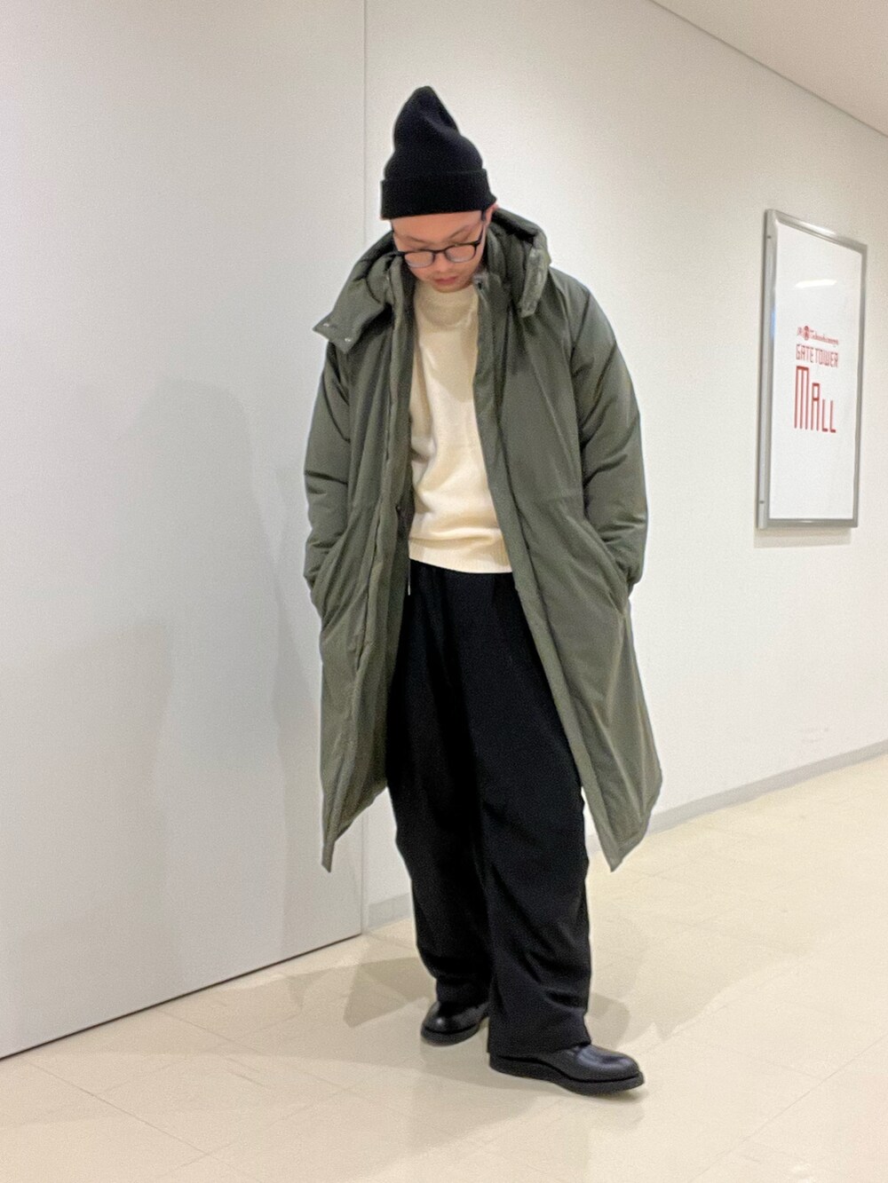 ホワイト系のニット/セーター、グリーン系のその他アウター、ブラック系のその他パンツを着用したメンズの秋コーディネートの2枚目の写真