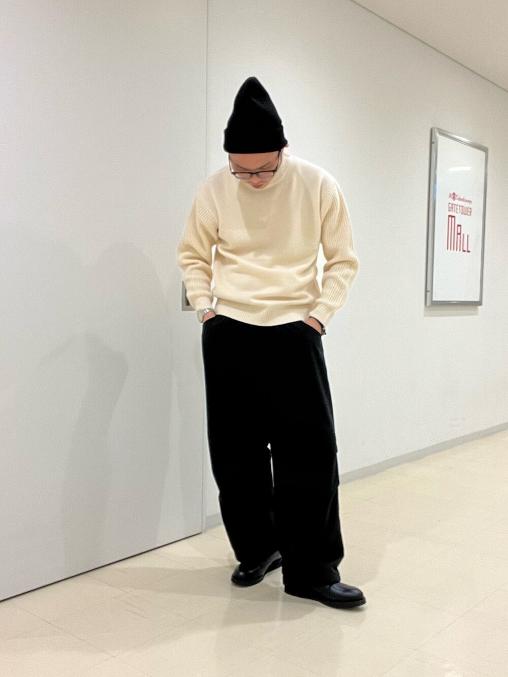 ホワイト系のニット/セーター、グリーン系のその他アウター、ブラック系のその他パンツを着用したメンズの秋コーディネートの3枚目の写真