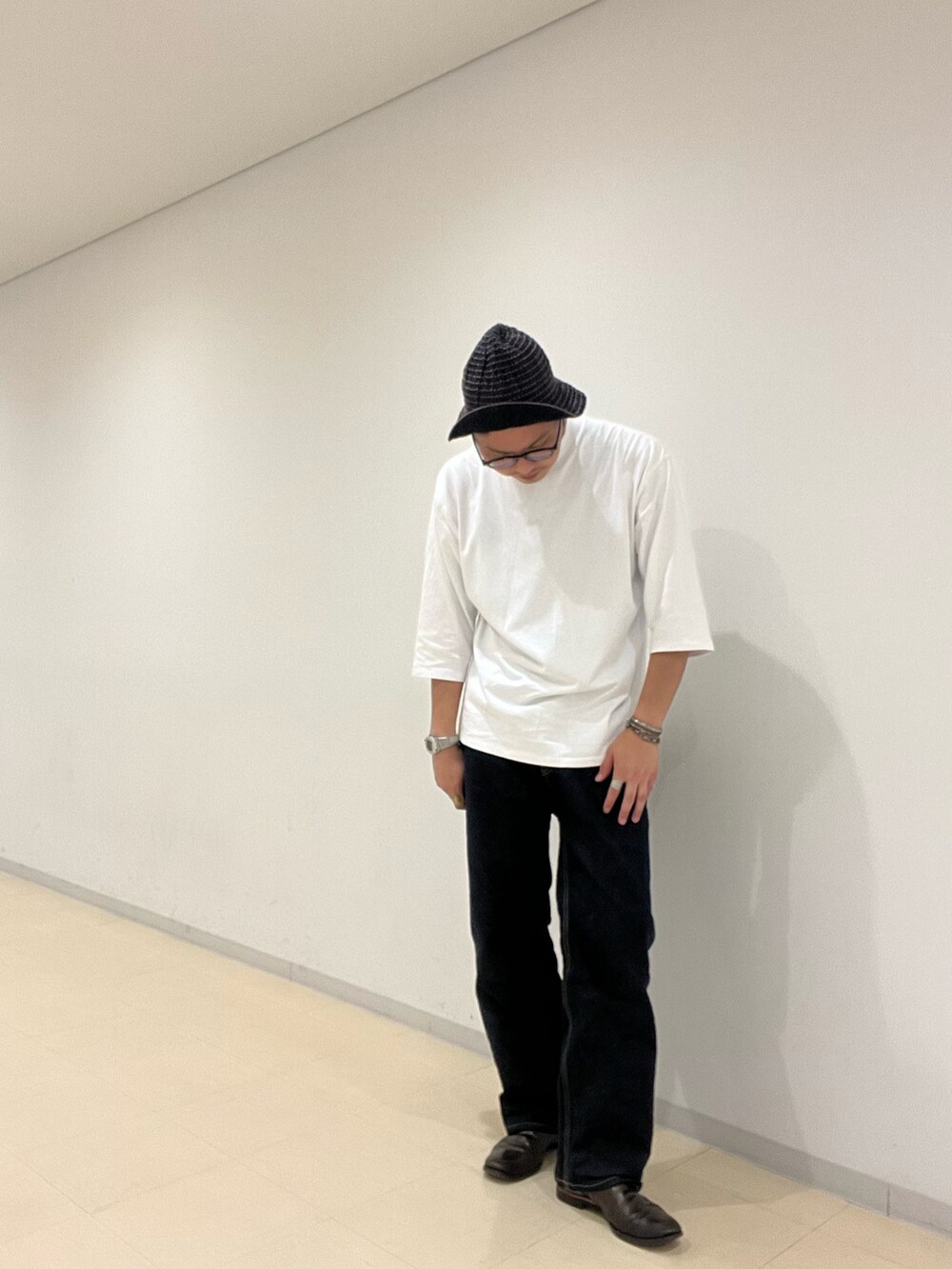 ブラウン系のブーツ、ブルー系のデニムパンツ、ホワイト系のTシャツ/カットソーを着用したメンズの秋コーディネートの5枚目の写真