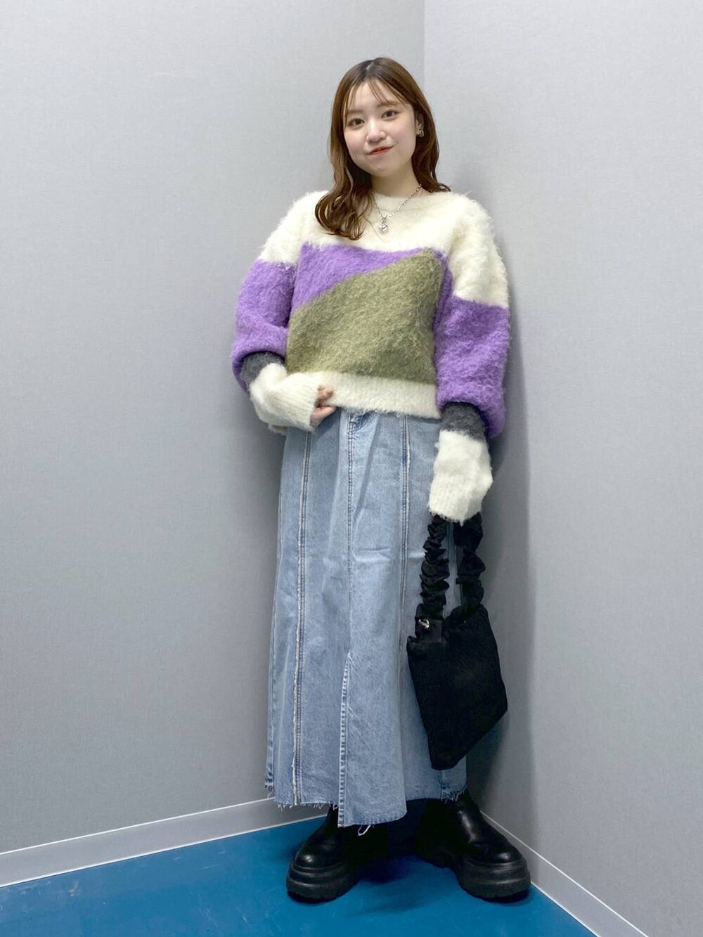 ブラック系のブーツ、ブラック系のショルダーバッグ、パープル系のニット/セーターを着用したレディースの冬コーディネートの4枚目の写真