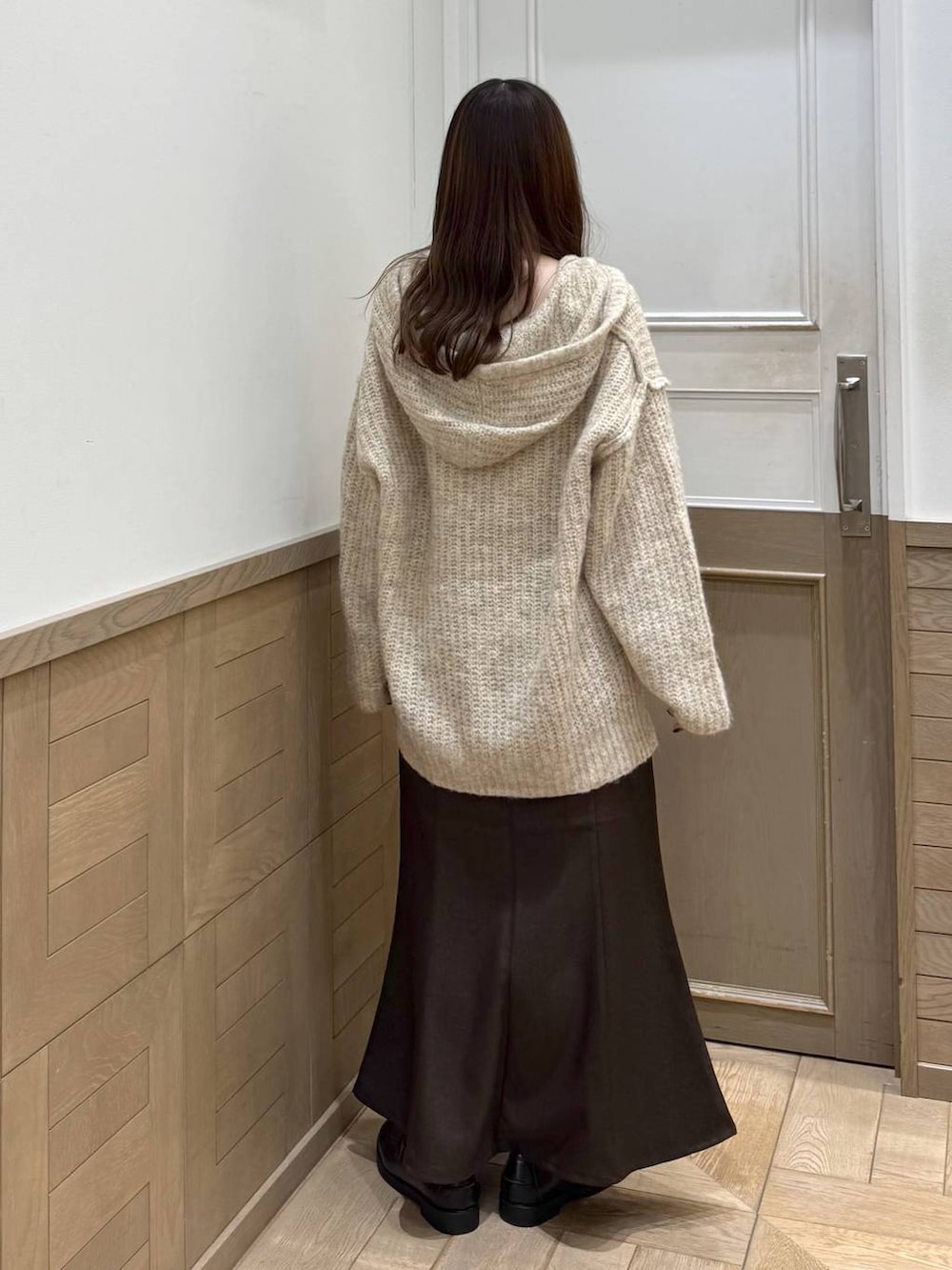 ホワイト系のニット/セーター、ブラック系のローファー、ブラウン系のスカートを着用したレディースの秋コーディネートの4枚目の写真