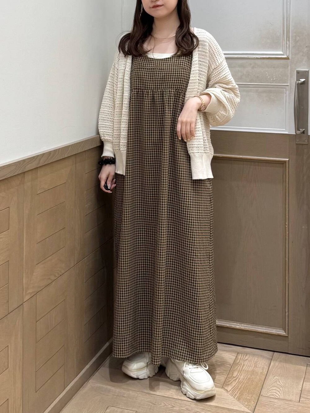 ホワイト系のスニーカー、ベージュ系のワンピース、ホワイト系のカーディガン/ボレロを着用したレディースの春コーディネートの2枚目の写真