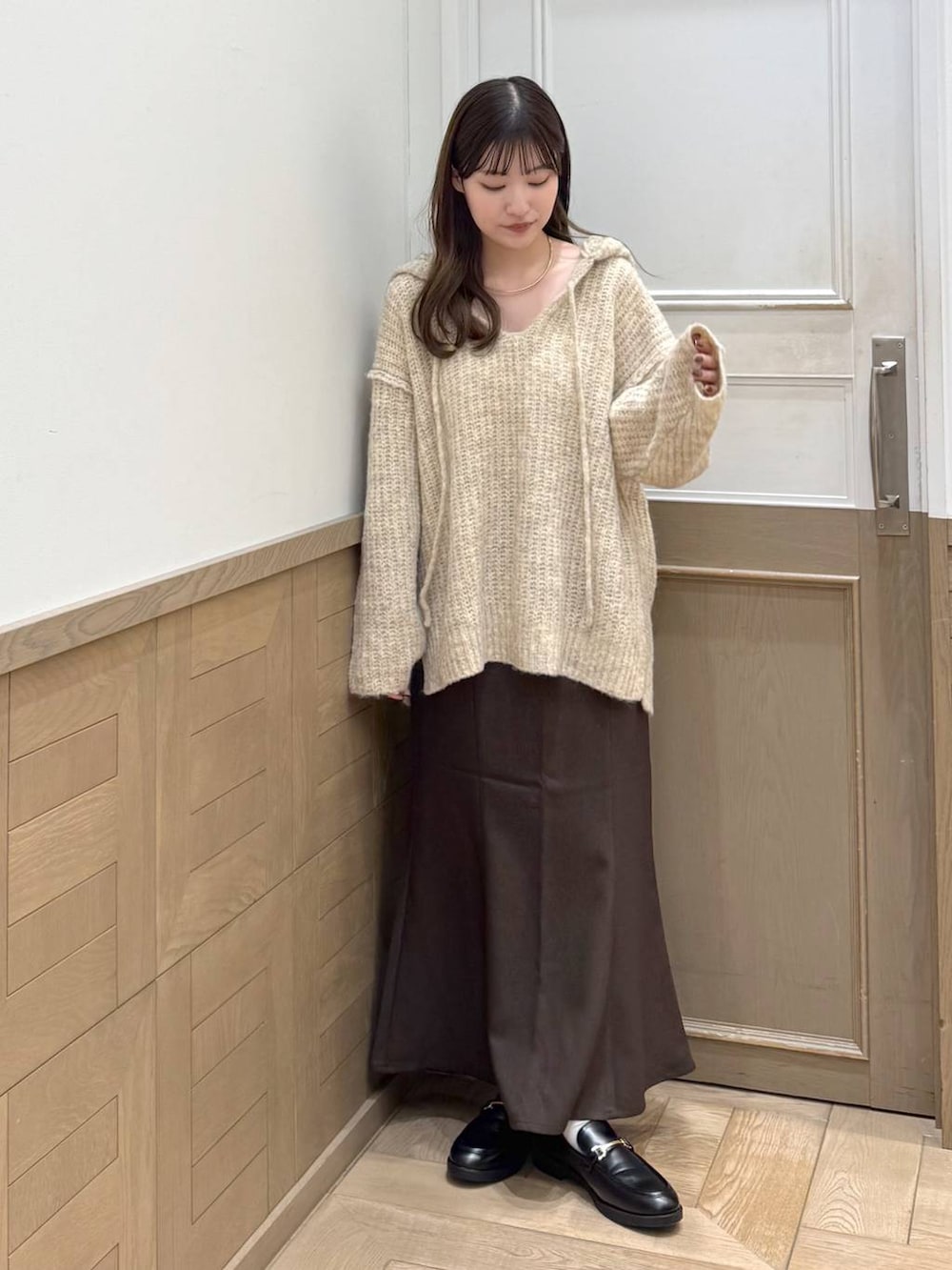 ホワイト系のニット/セーター、ブラック系のローファー、ブラウン系のスカートを着用したレディースの秋コーディネートの5枚目の写真
