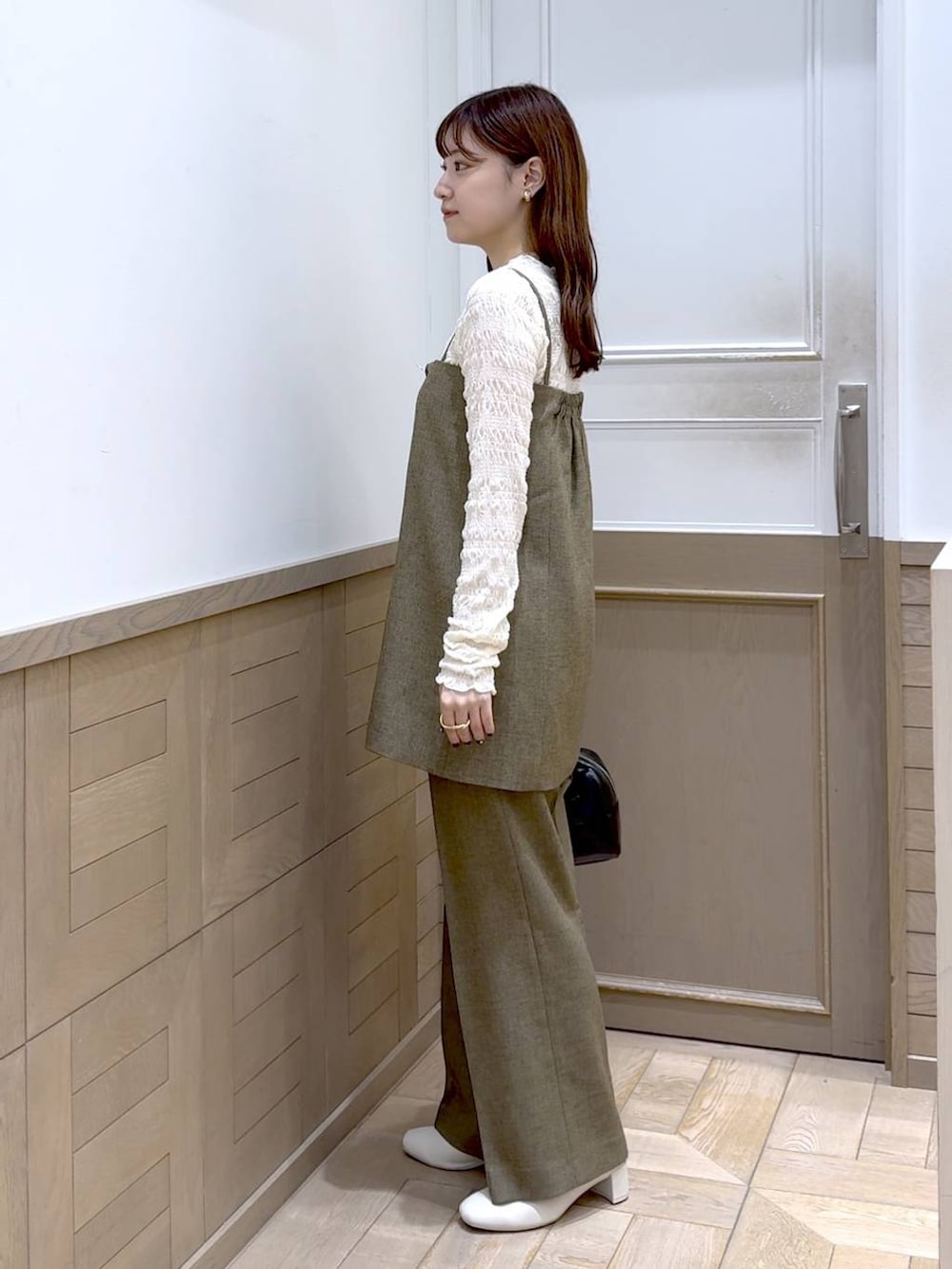 ホワイト系のTシャツ/カットソー、ホワイト系のブーツ、ブラック系のボストンバッグを着用したレディースの秋コーディネートの2枚目の写真