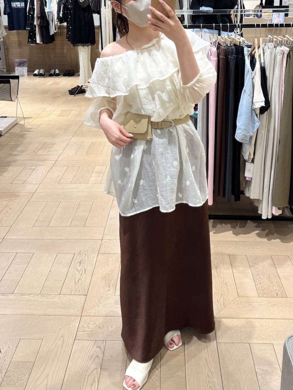 ホワイト系のワンピース、ブラウン系のスカート、ホワイト系のサンダルを着用したレディースの夏コーディネートの2枚目の写真