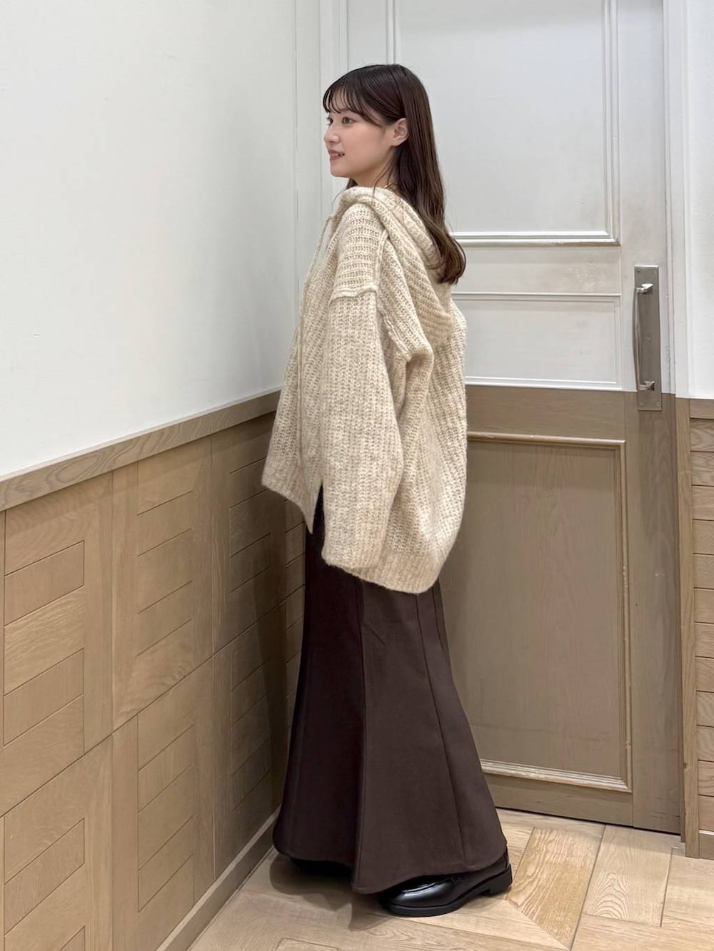 ホワイト系のニット/セーター、ブラック系のローファー、ブラウン系のスカートを着用したレディースの秋コーディネートの3枚目の写真