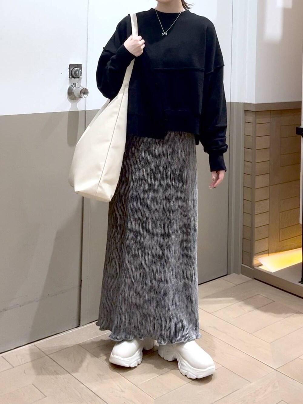 ホワイト系のショルダーバッグ、グレー系のスウェット、ホワイト系のブーツを着用したレディースの秋コーディネートの4枚目の写真