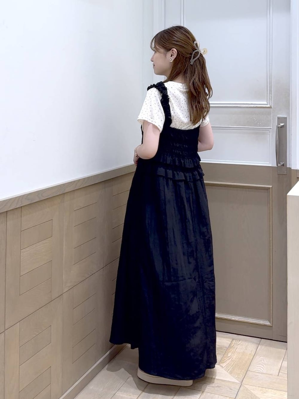 ホワイト系のショルダーバッグ、ホワイト系のサンダル、ブラック系のワンピースを着用したレディースの夏コーディネートの3枚目の写真