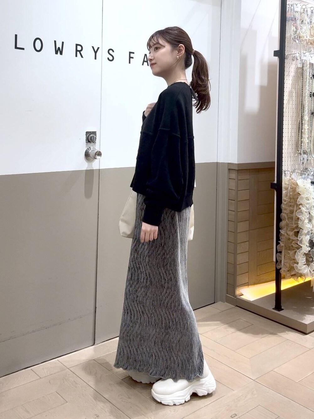 ホワイト系のショルダーバッグ、グレー系のスウェット、ホワイト系のブーツを着用したレディースの秋コーディネートの2枚目の写真