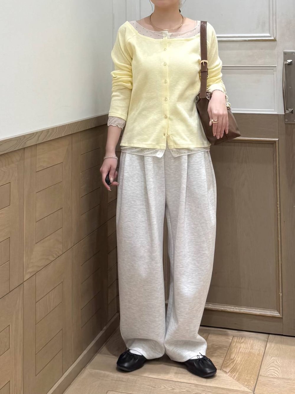 グレー系のスウェットパンツ、ブラウン系のショルダーバッグ、イエロー系のTシャツ/カットソーを着用したレディースの冬コーディネートの5枚目の写真